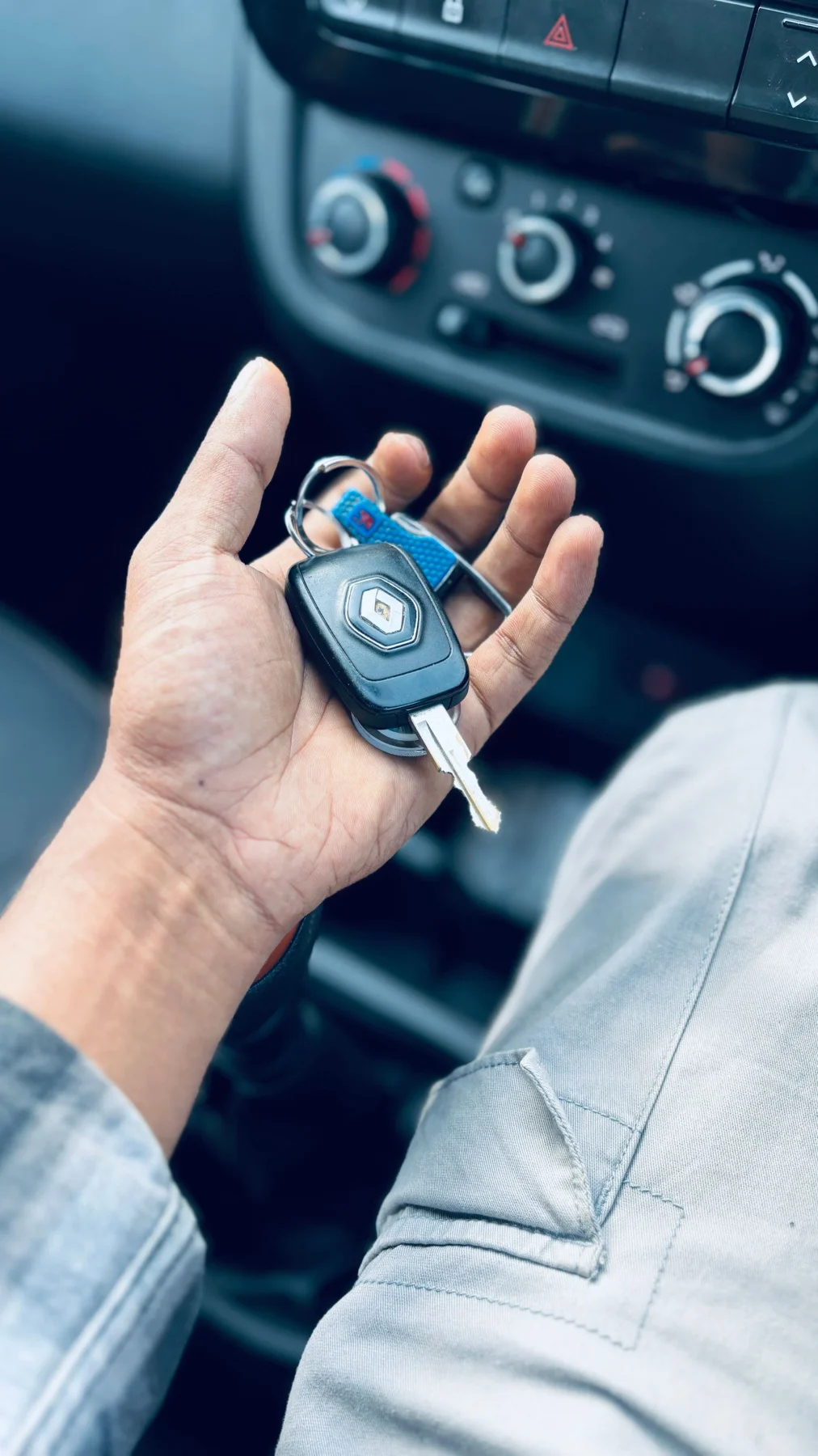 Chaves de um automóvel na mão, em frente à consola central